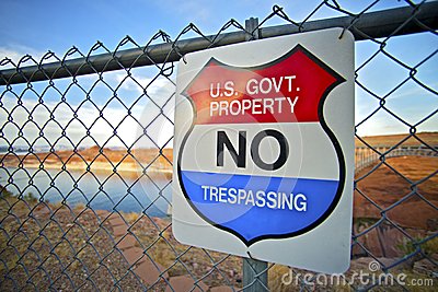No Trespassing Us Government Property Warning Sign On Fence