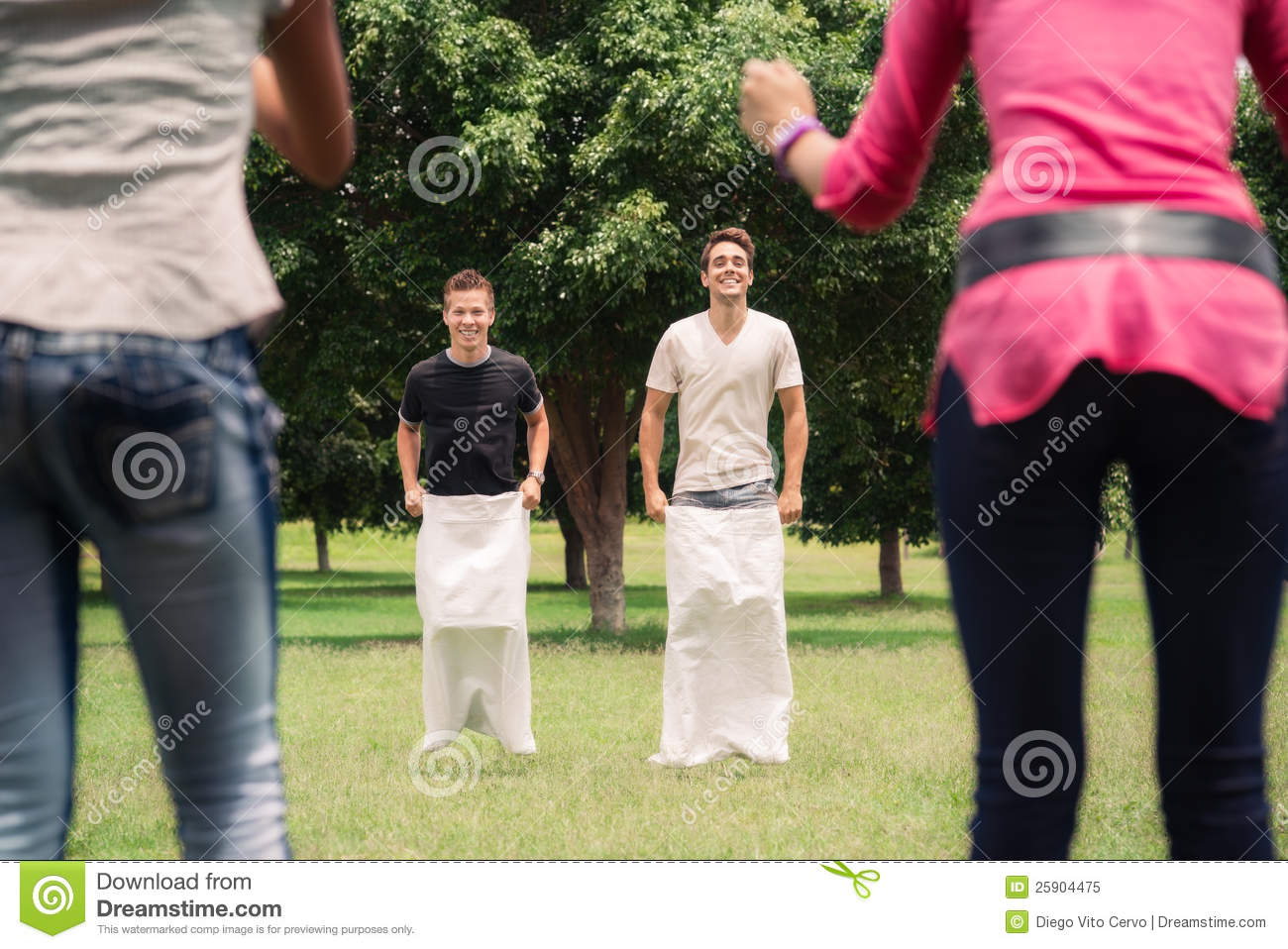     Playing Sack Race In City Park With Women Clapping Hands And Laughing