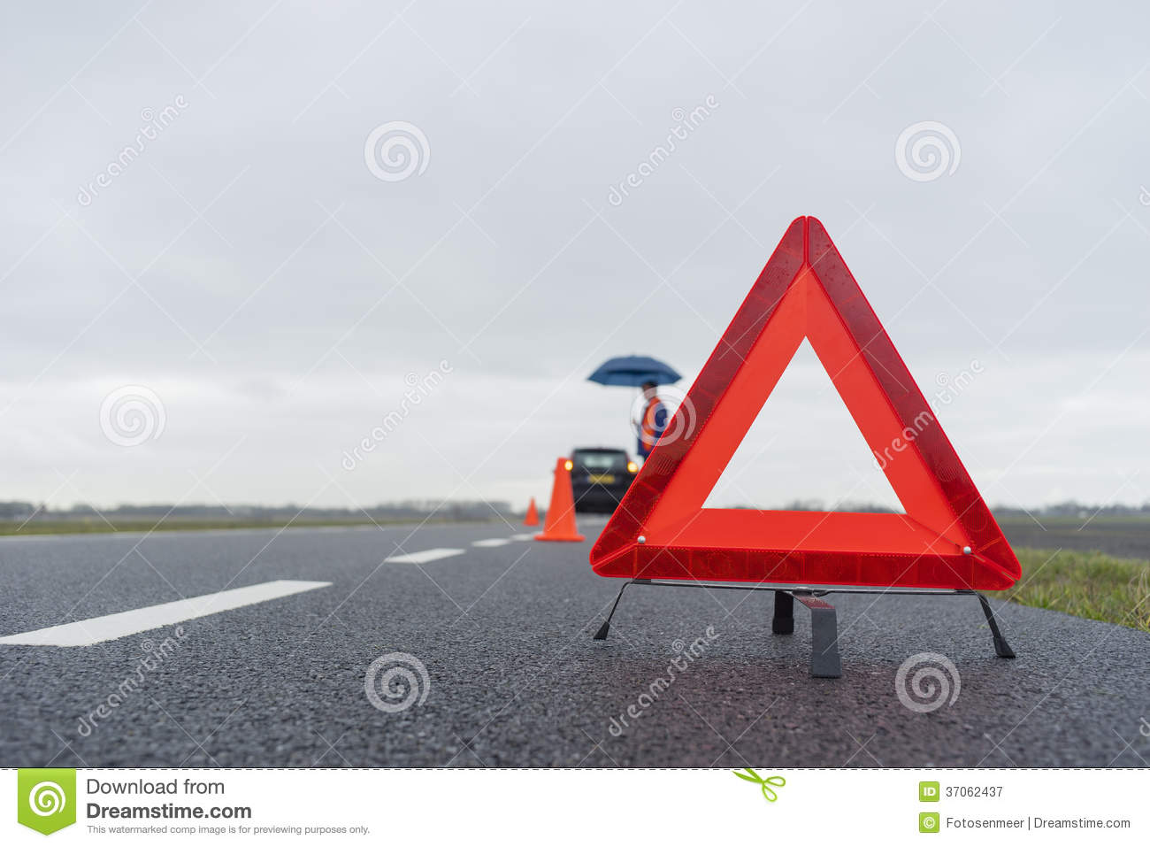 Man With An Umbrella Besides His Broken Car Alongside A Road In The