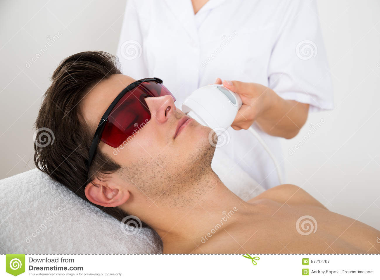 Young Man Receiving Laser Hair Removal Treatment At Beauty Center