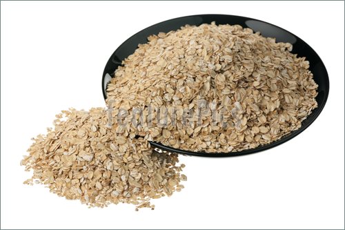 Rolled Oats In A Black Ceramic Plate On A White Background