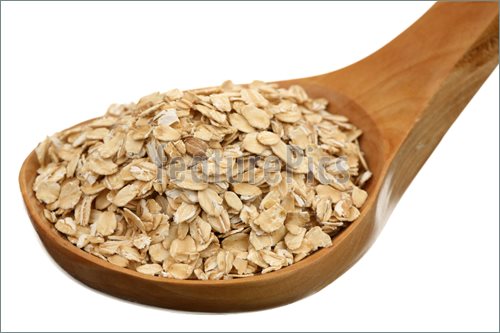 Rolled Oats In A Wooden Spoon On A White Background