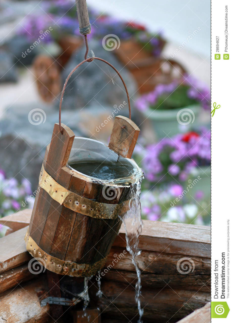 Wooden Bucket Over The Well With Flowing Water And Cobwebs On Summer    