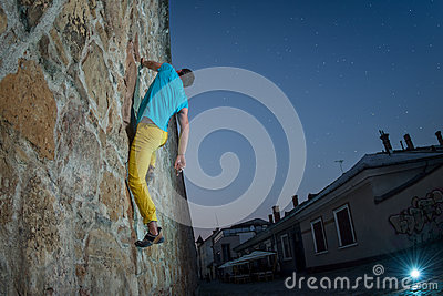 Climber Bouldering On A Stone Wall In The City Center