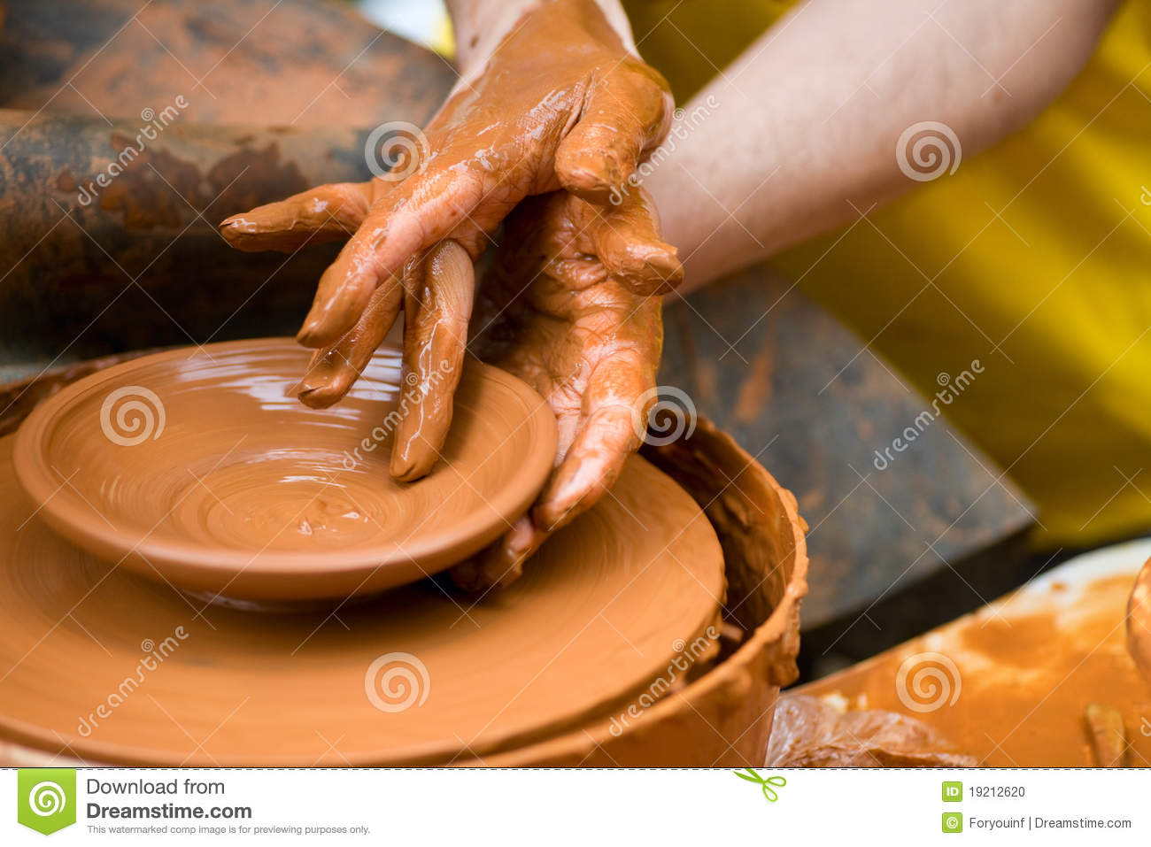 Potter Shaping A Ceramic Plate On A Pottery Wheel