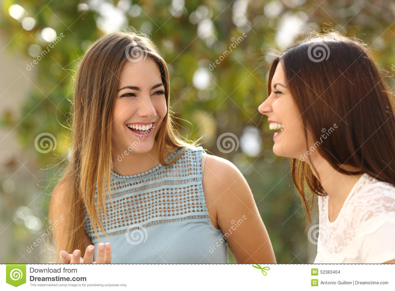 Happy Women Talking And Laughing In A Park With A Green Background 