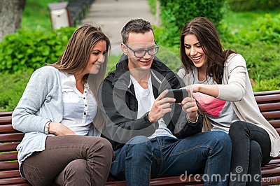 Women Sitting Outdoor On A Bench In Park Talking Having Fun Laughing