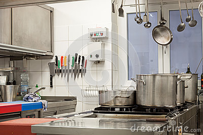 Of A Commercial Kitchen With Wall Mounted Utensils And A Range