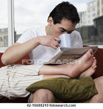 Man Drinking Coffee And Reading Newspaper With Girlfriend S Feet In