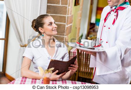 Waiter Brings A Dish For A Nice Woman At The Restaurant She Looks At    