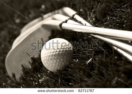 Black And White Photo Of Golf Clubs And A Golf Ball In Low Light For