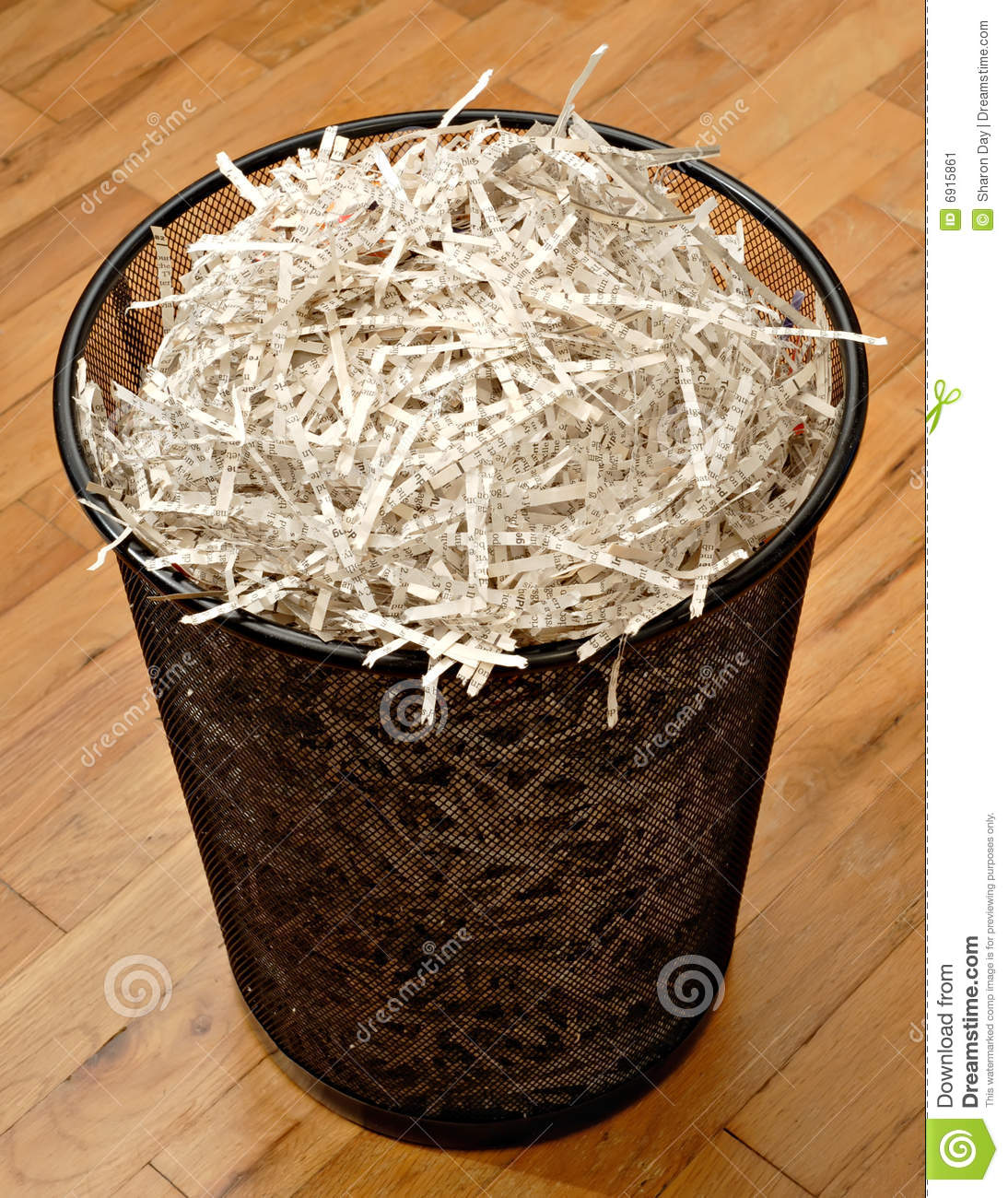 Wire Trash Basket Full Of Shredded Paper On A Hardwood Floor