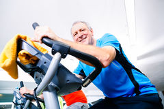 Senior Doing Sport On Spinning Bike In Gym Stock Images