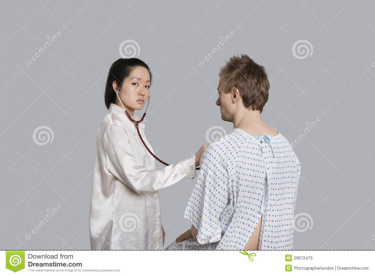 Portrait Of A Young Female Doctor Examining Male Patient Royalty Free    