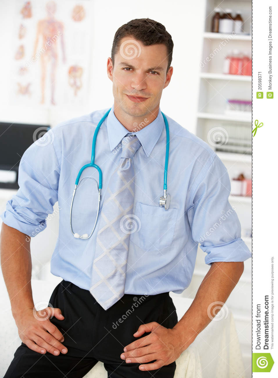Young Male Doctor In Consulting Room Looking At Camera 