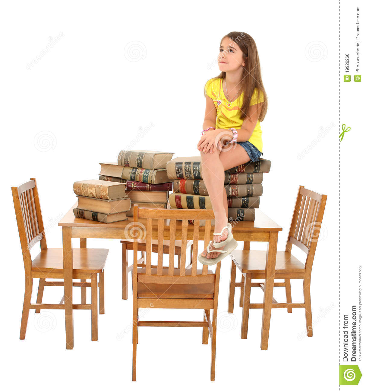 Young Student Sitting On Stack Of Books On Table Over White
