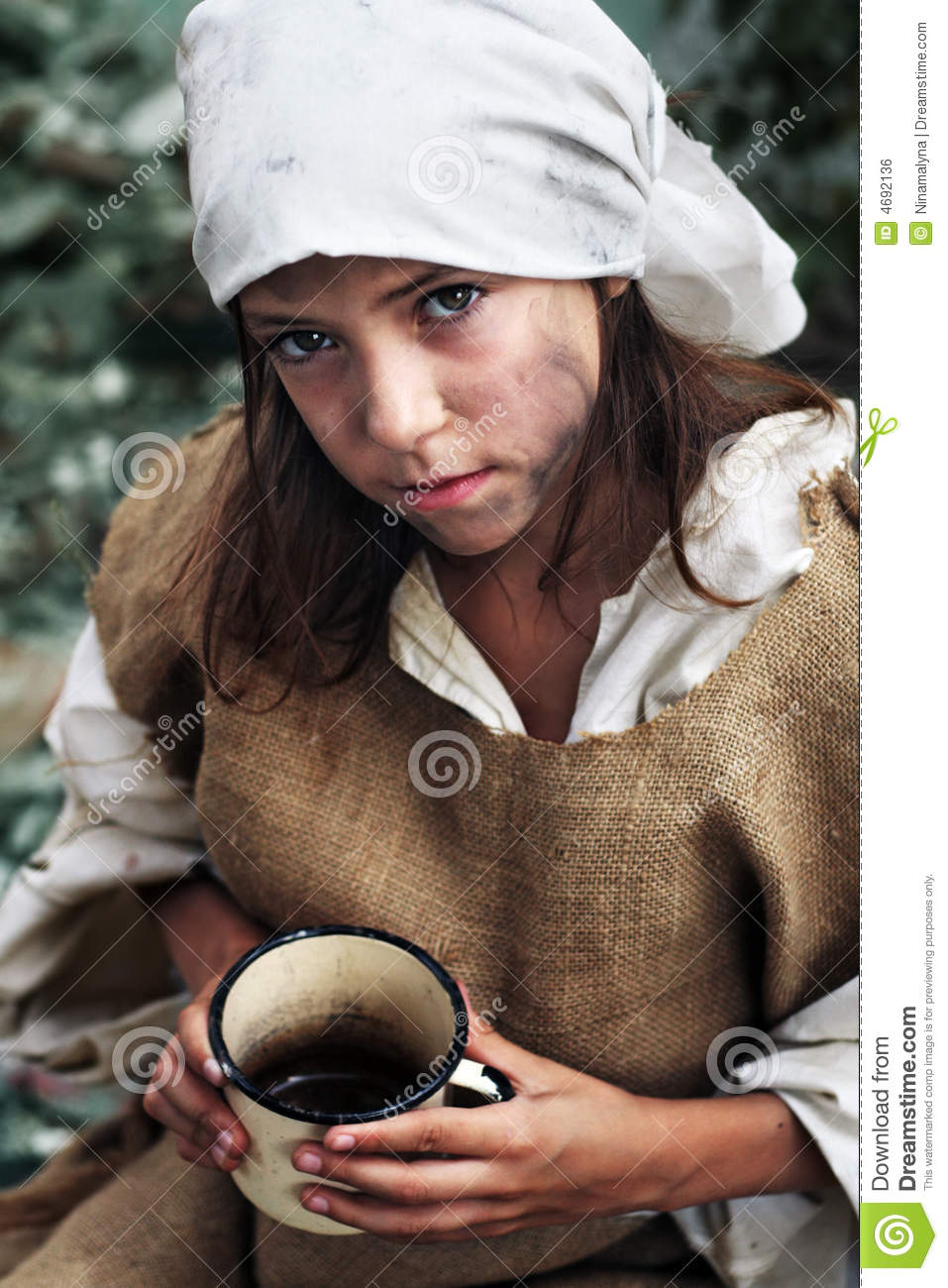 Poor Little Girl Wearing Dirty Clothes With A Vintage Mug In Her Hands    