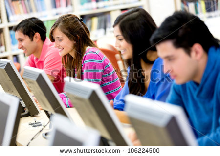Group Of Young People Studying At The Library Using Computers Stock
