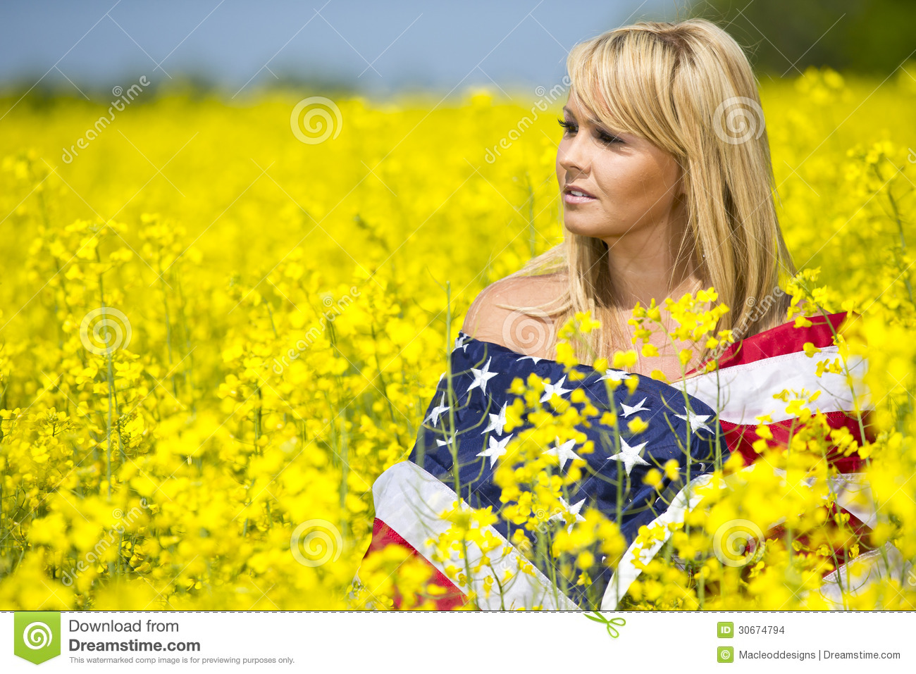 Girl Is Wrapped In The American Flag In A Field Of Yellow Flowers