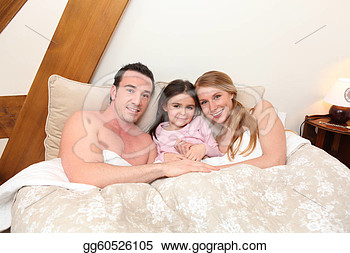 Family Cuddling In Bed Together