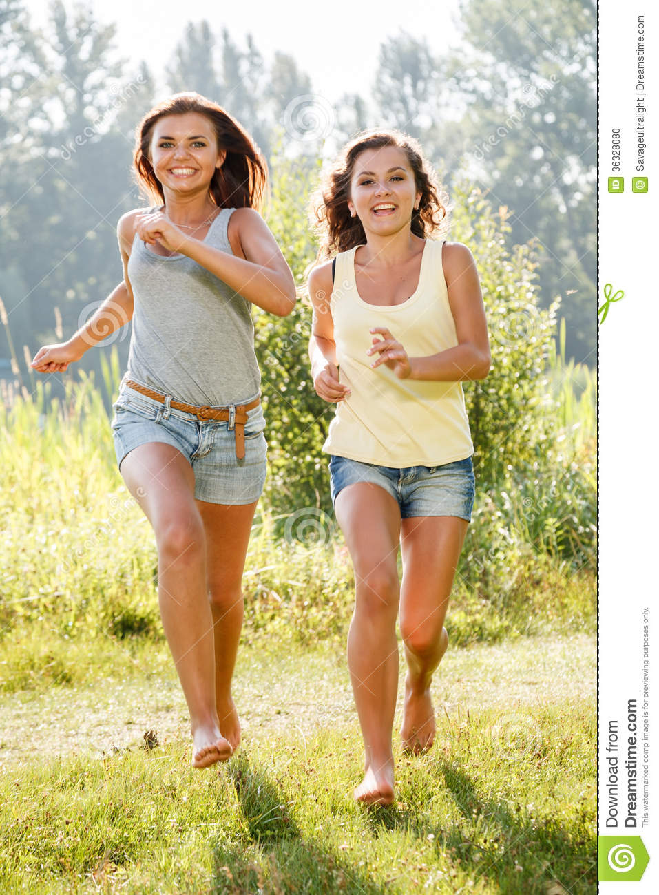 Two Teenage Girls Running On Grass Barefoot