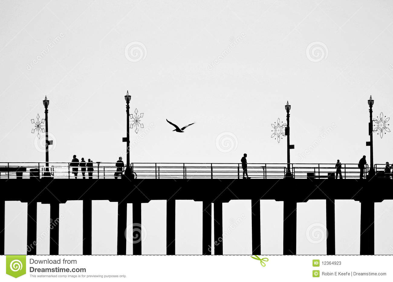 Pier With Four Lampposts Is Seen In Silhouette As People Walk On It