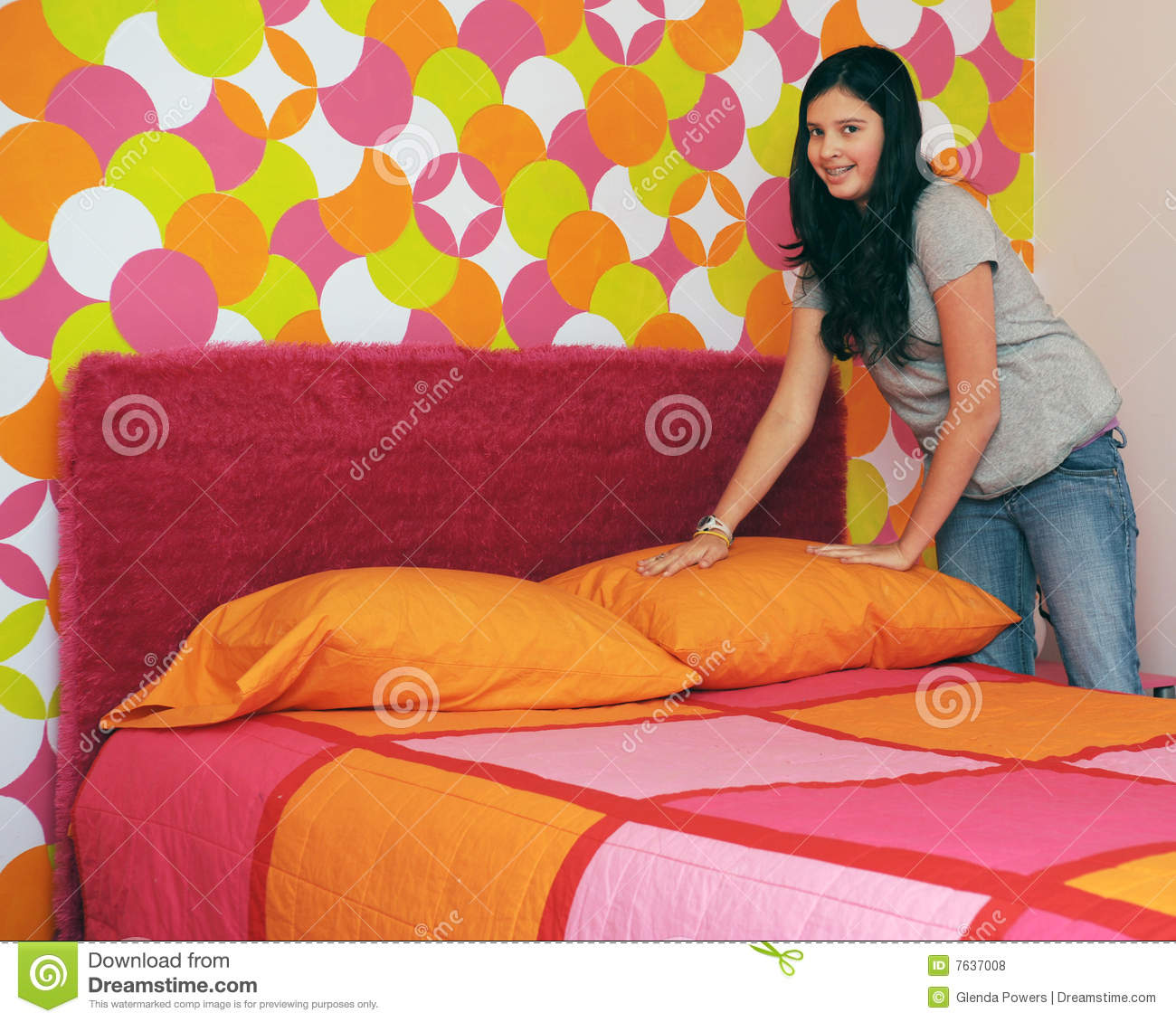 Preteen Girl Happily Making Her Bed In Her Very Colorful Room
