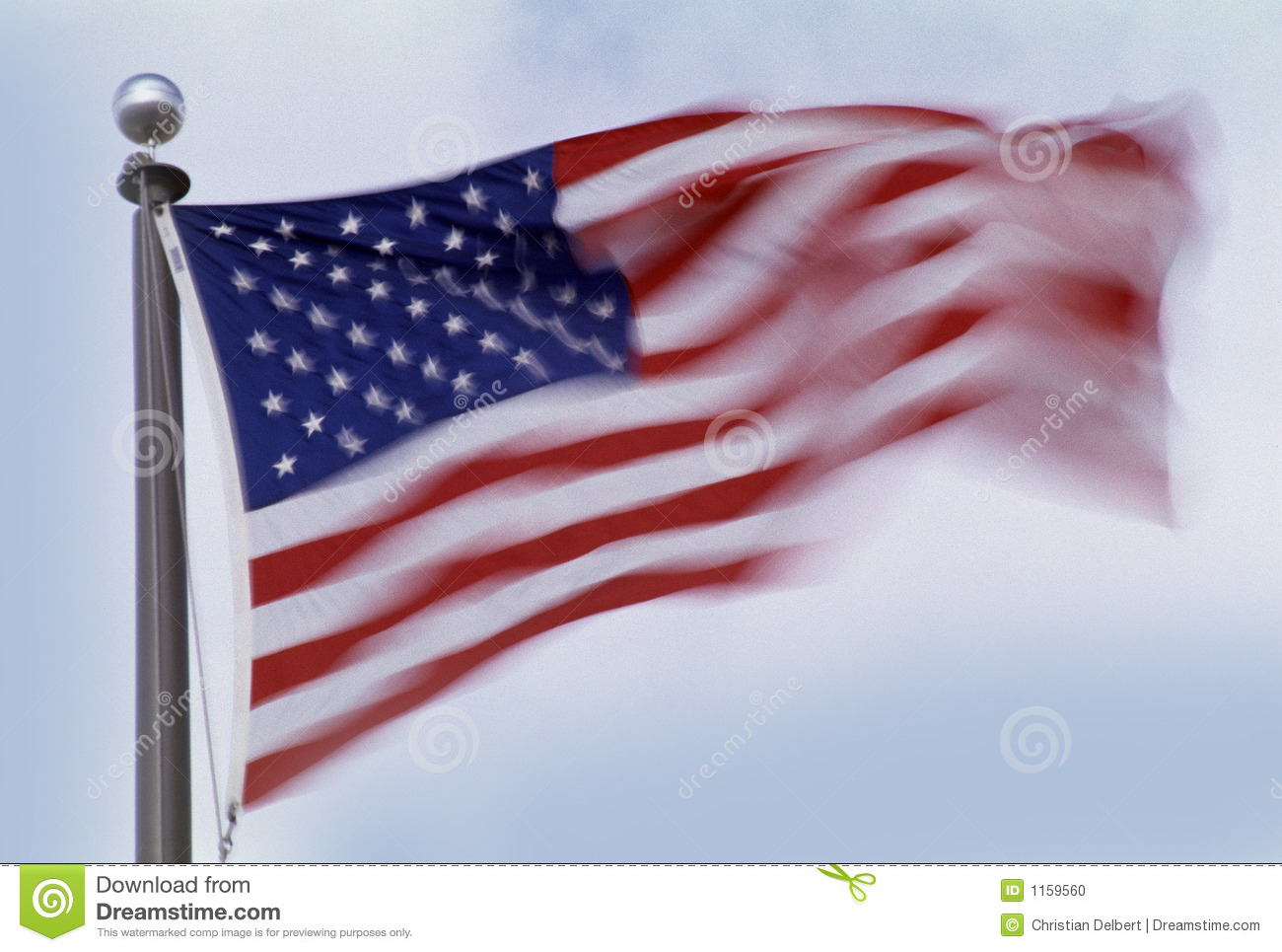 American Flag On Pole Blowing In The Wind With Motion On Light Blue    
