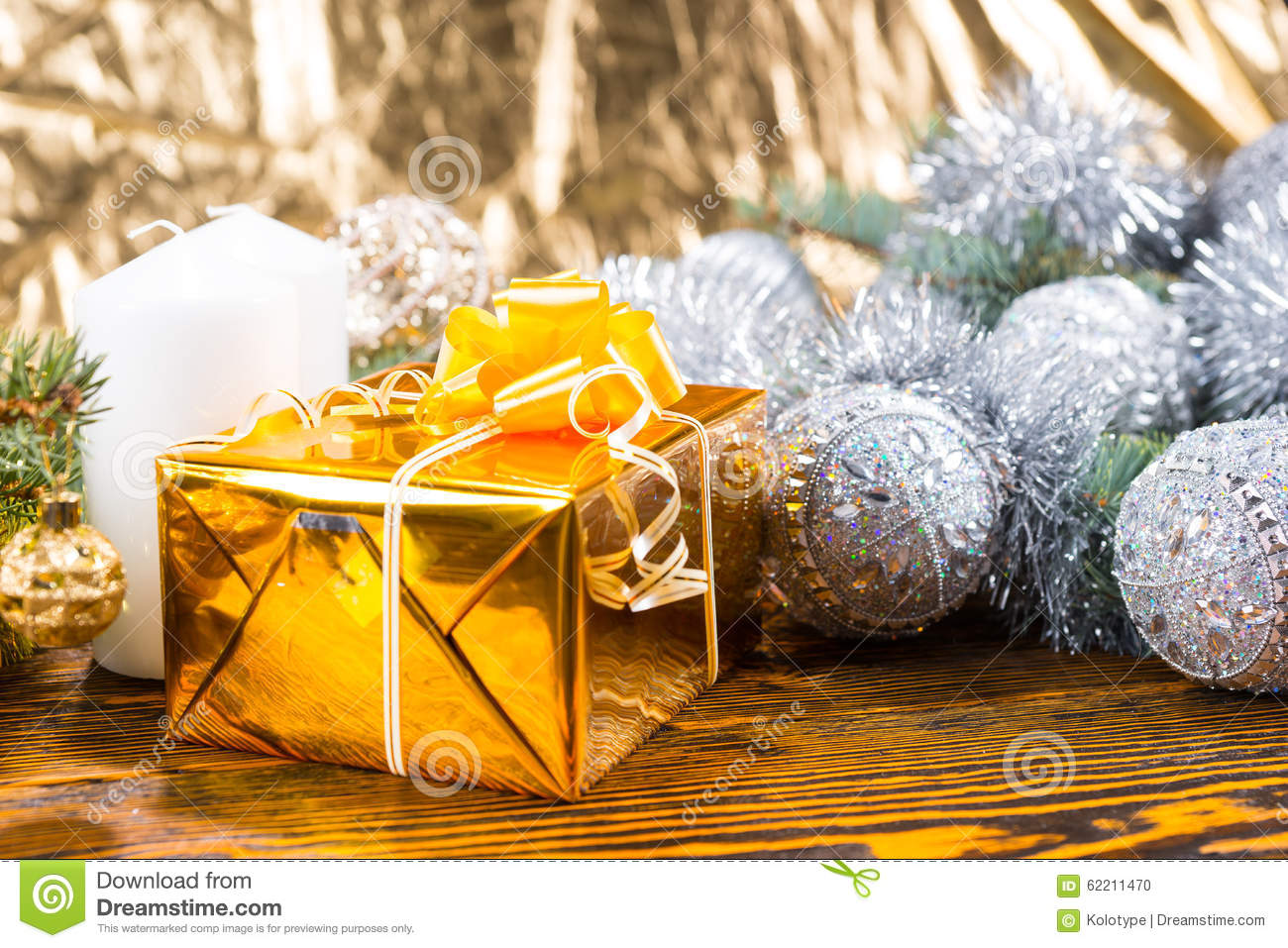 Of Christmas Gift Wrapped In Gold On Rustic Wooden Table With Candle
