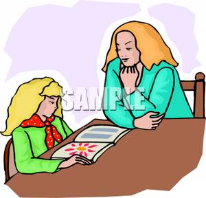 Teacher Sitting With A Student Reading A Magazine   Royalty Free
