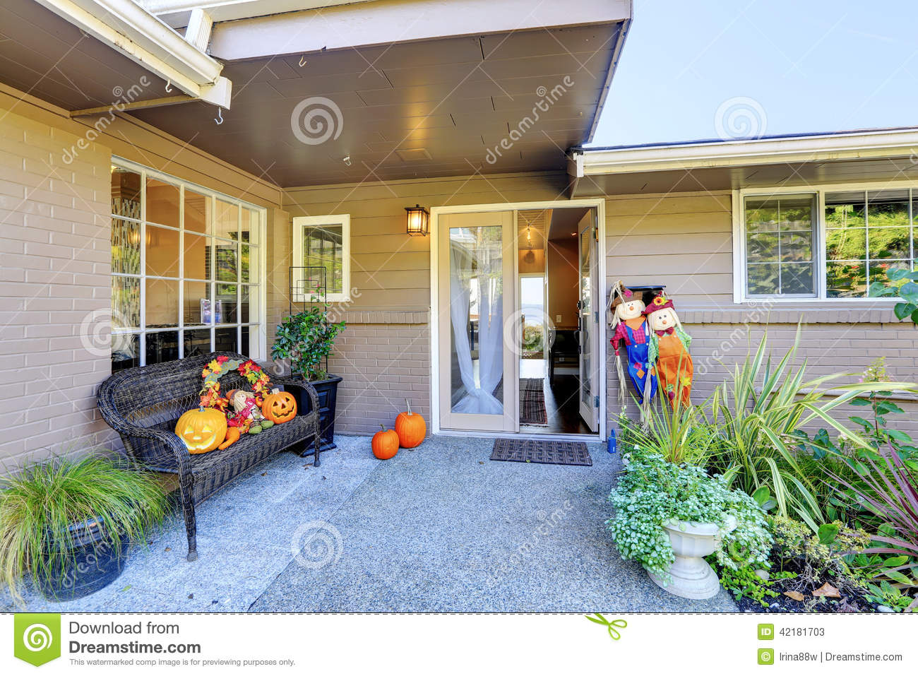 Entrance Porch With Wicker Bench Flower Pots And Pumpkin Decoration