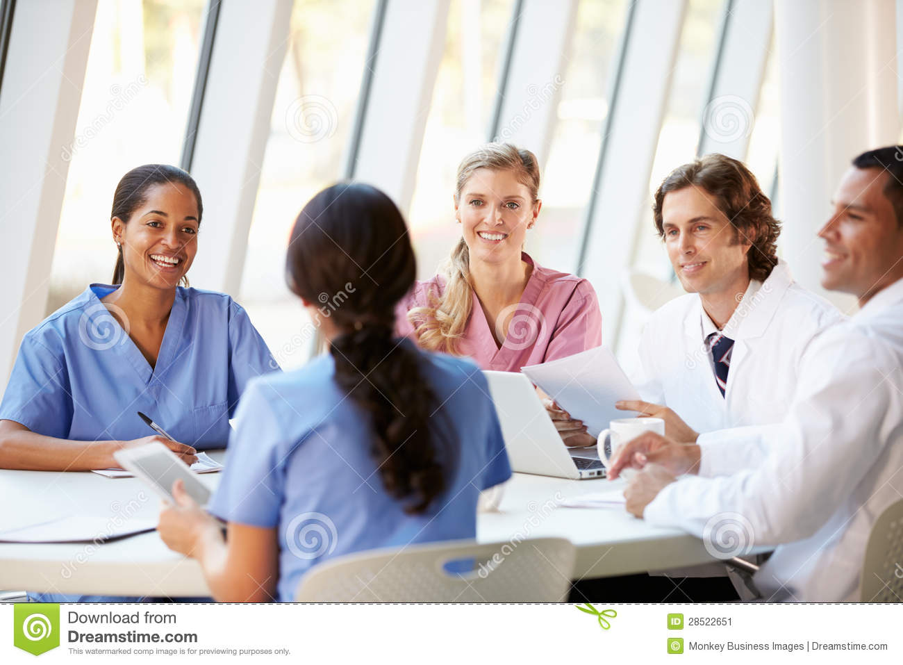 Medical Team Meeting Around Table In Modern Hospital Stock Image