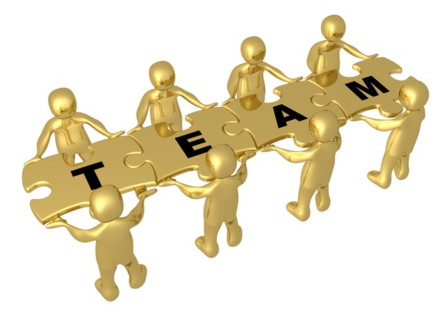 Team Of 8 Gold People Holding Up Connected Pieces To A Colorful Puzzle