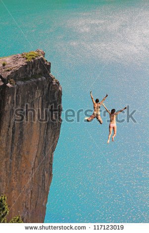 Two Cliff Jumping Girls Against Turquoise Ocean   Stock Photo