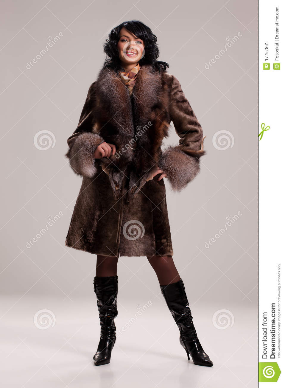 Young Attractive Woman In A Fur Coat On Isolated Background