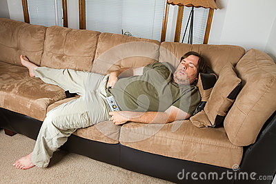 Fat Man Sleeping On The Couch With His Hand Down His Pants