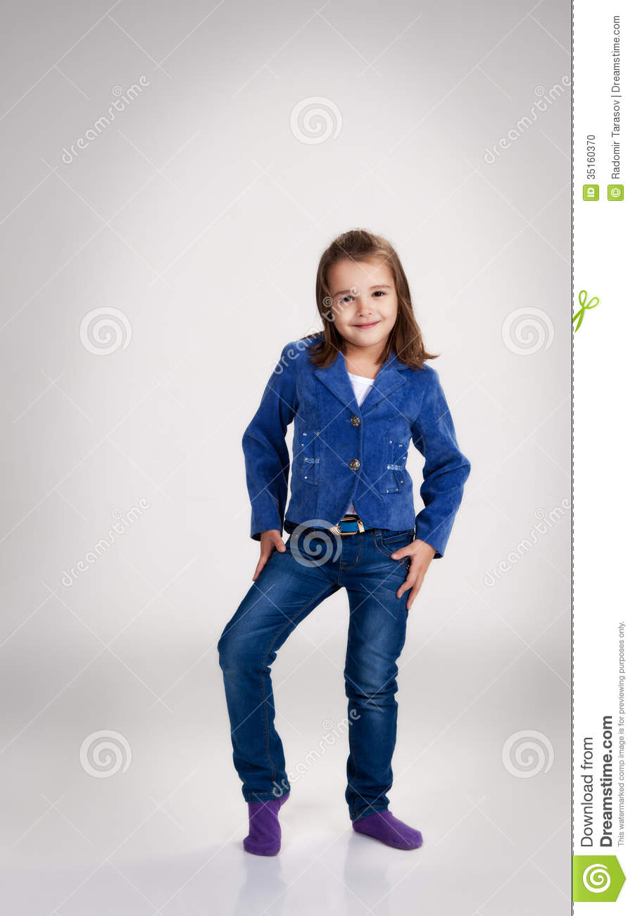 Little Girl In Blue Jeans And Jacket Posing In The Studio Stock Photo