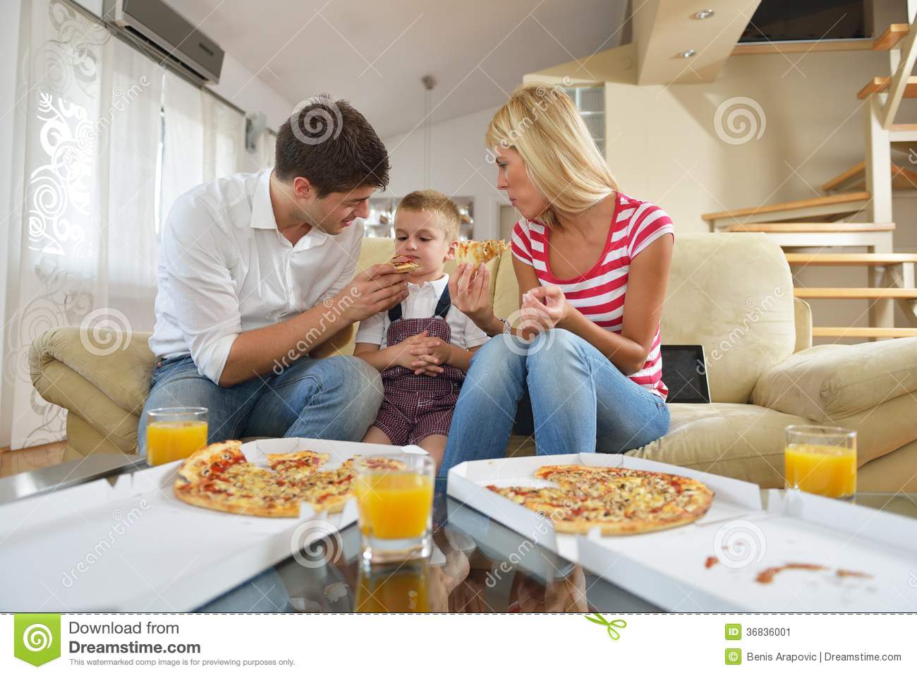 Happy Young Family Eating Tasty Pizza With Cheesa And Dring Healthy
