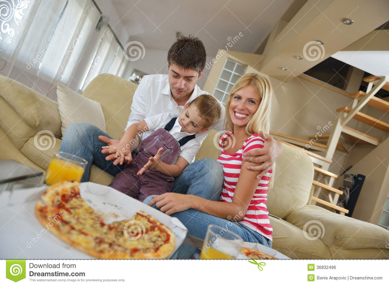Happy Young Family Eating Tasty Pizza With Cheesa And Dring Healthy