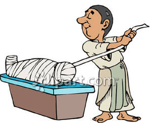 Egyptian Man Wrapping Up A Mummy   Royalty Free Clipart Picture