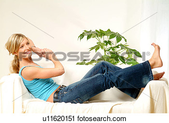 Stock Photography Of Woman Relaxing On Sofa Looking At Her Toes
