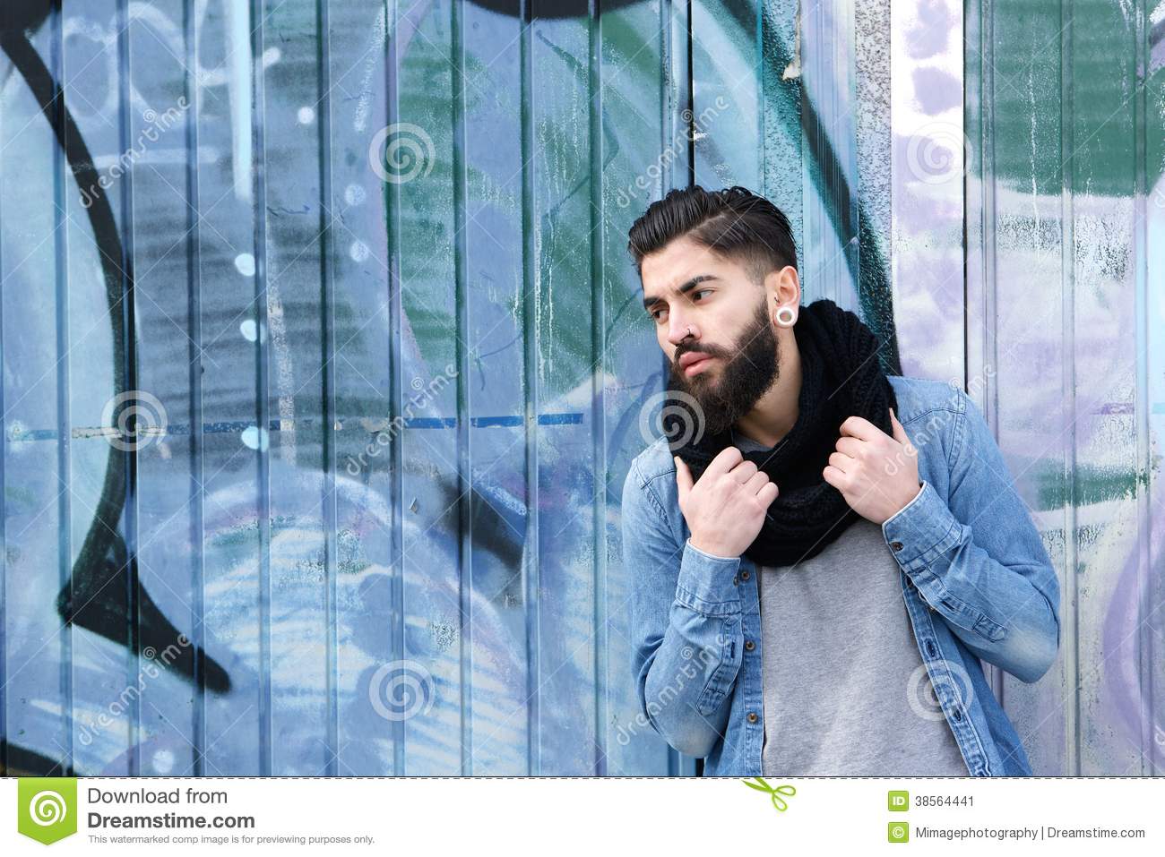 Portrait Of A Male Fashion Model With Beard Posing Against Graffiti